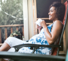 Image of a pregnant woman sitting on a chair and holding a mug.