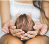 Image of a baby being cradled on its back on an adult’s lap.