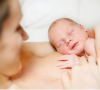 Image of a baby sleeping on a woman’s chest.